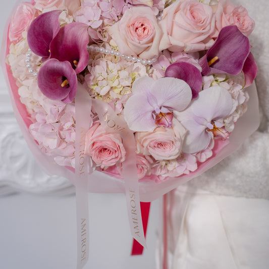 Close-up of blush garden roses, purple calla lilies, pink hydrangeas, lavender orchid and pearl strand detail with AMEROSE ribbon — luxury romantic bouquet London