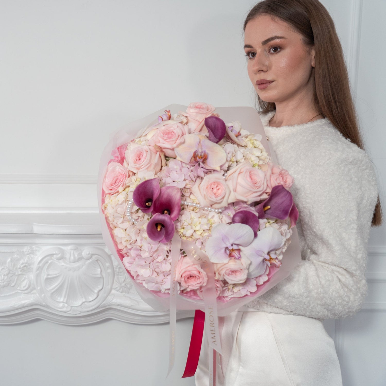 Women in white holding AMEROSE bouquet made of hydrangea, calla, phalaenopsis and garden roses