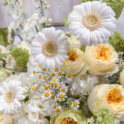 Close-up of white gerbera, butter garden roses, chamomile and green viburnum in a luxury flower arrangement — AMEROSE hatbox flowers London
