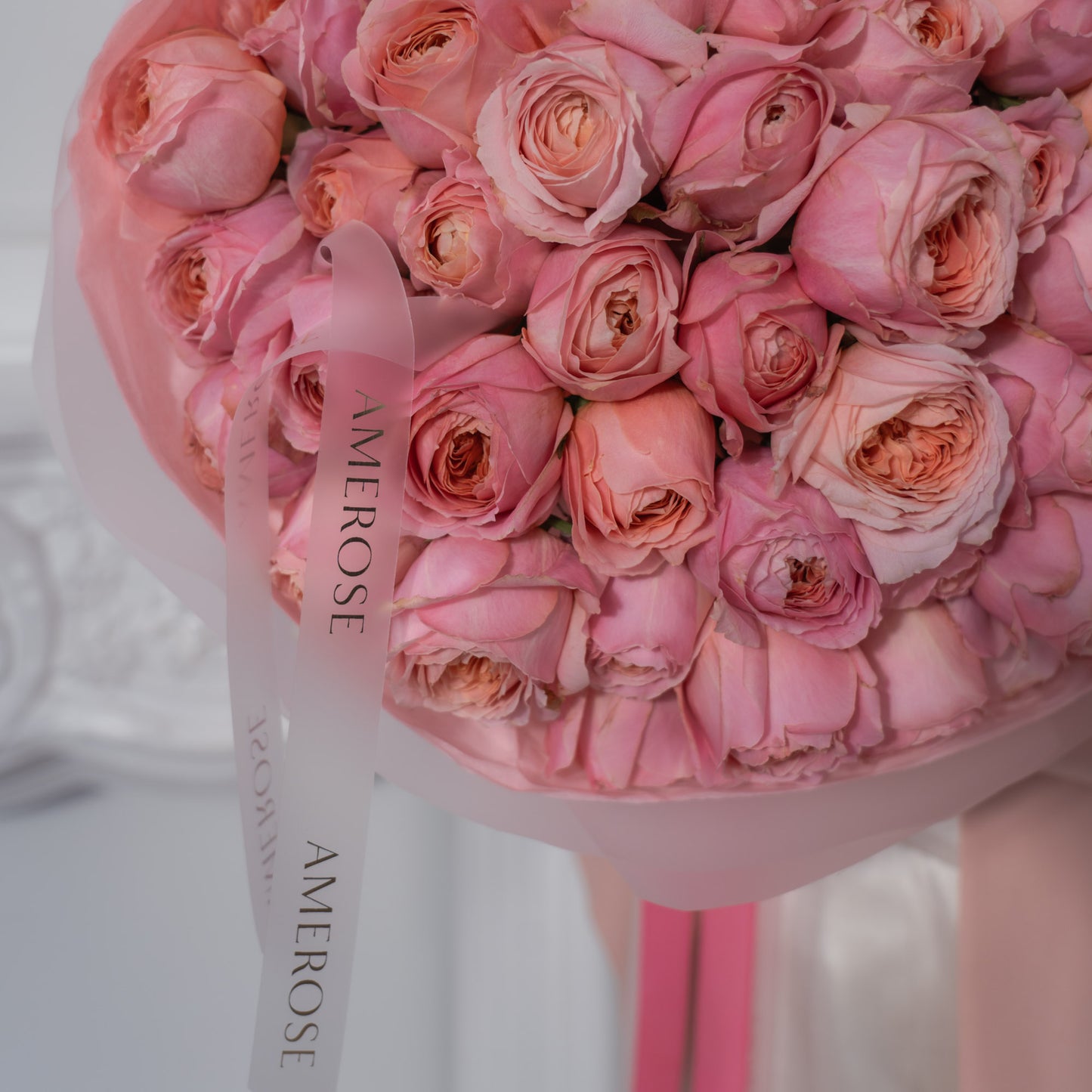 Close-up of densely packed blush pink garden roses with ruffled petals and AMEROSE silicon ribbon — luxury pink rose bouquet detail, London