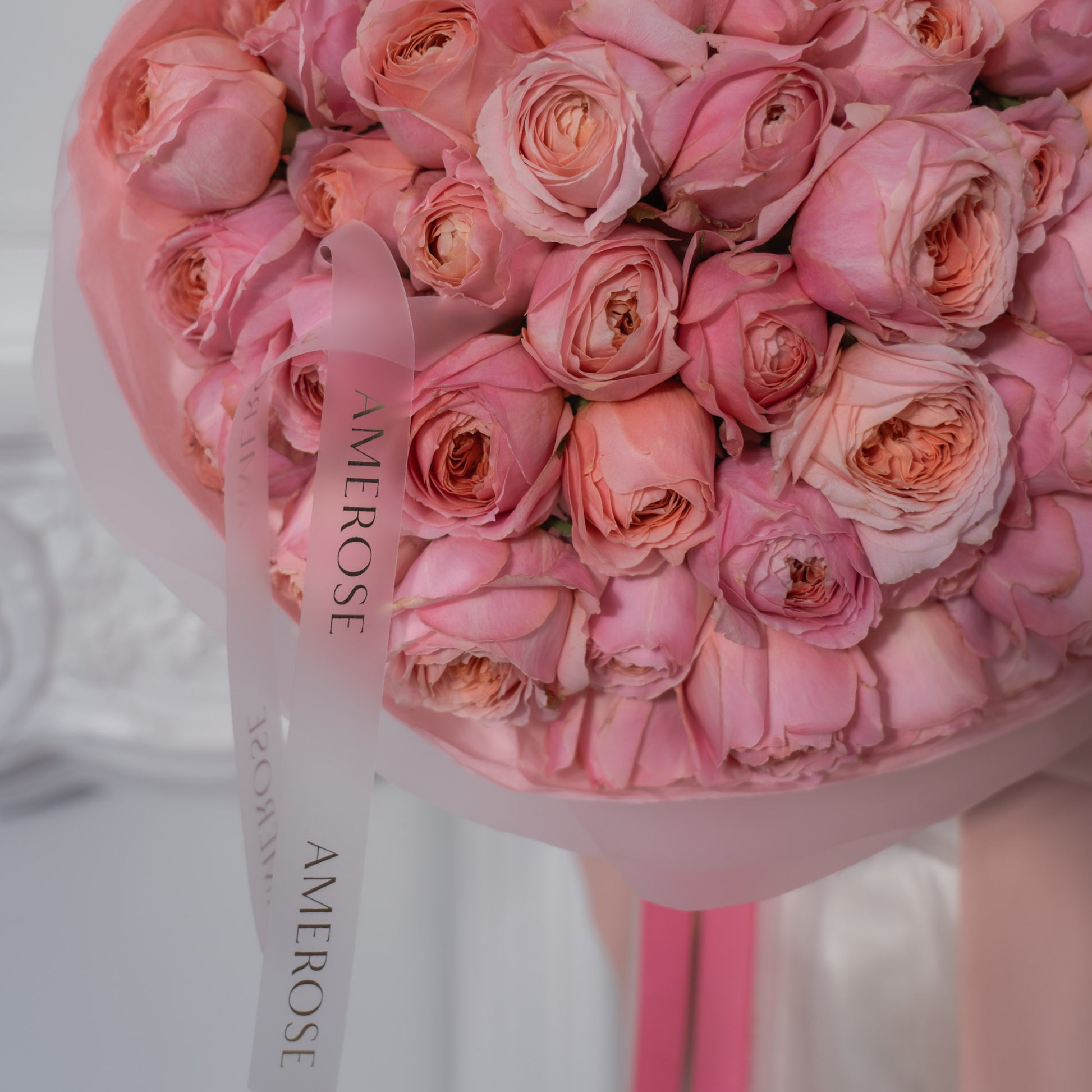 Close-up of densely packed blush pink garden roses with ruffled petals and AMEROSE silicon ribbon — luxury pink rose bouquet detail, London