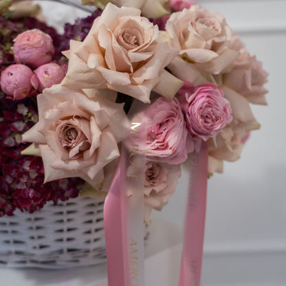 Close-up of blush nude garden roses, pink spray roses, and burgundy hydrangeas with AMEROSE branded satin ribbon — luxury flower arrangement detail, London