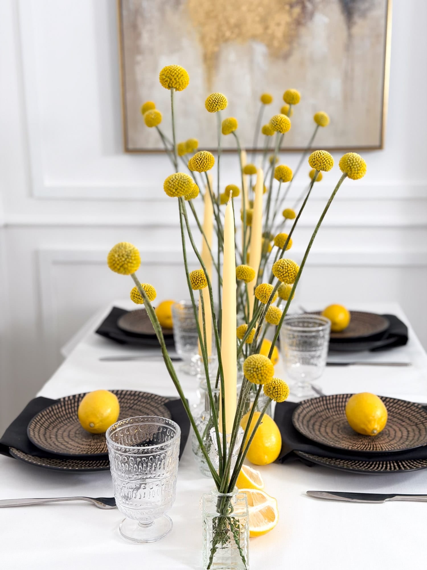 Dining table setting with yellow floral craspedia arrangement and lemons by AMEROSE London